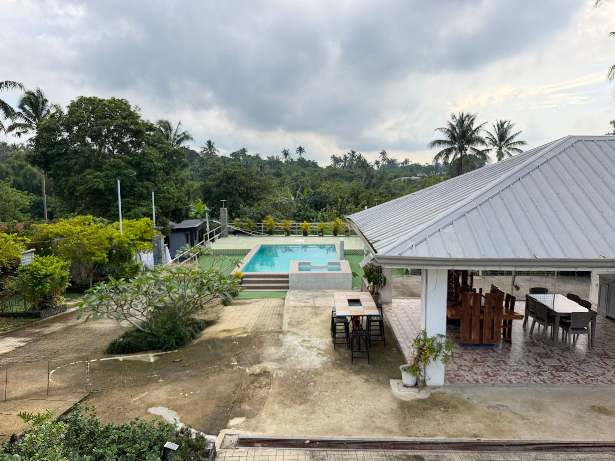 Looking down on the pavilion and the pool deck, with tree-covered hills behind